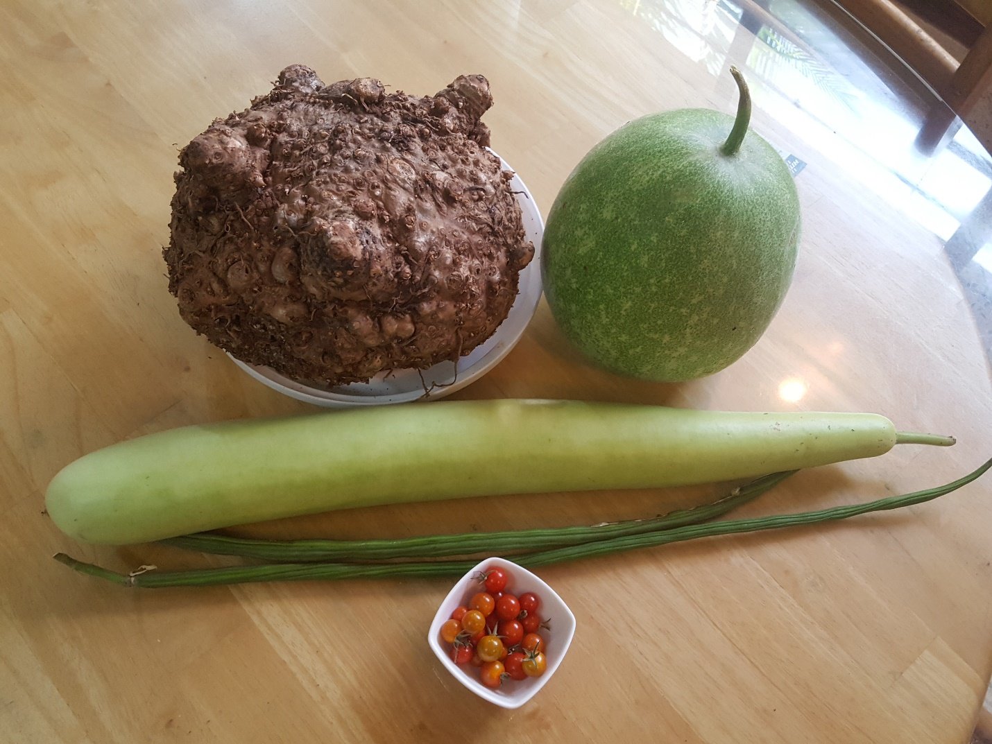 A bowl of fruit sitting on a wooden table Description automatically generated